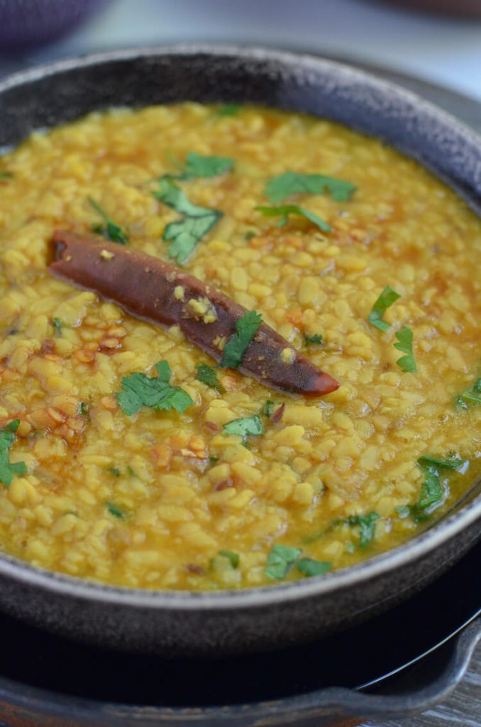 white urad dal is served in bowl with green coriander garnishing.