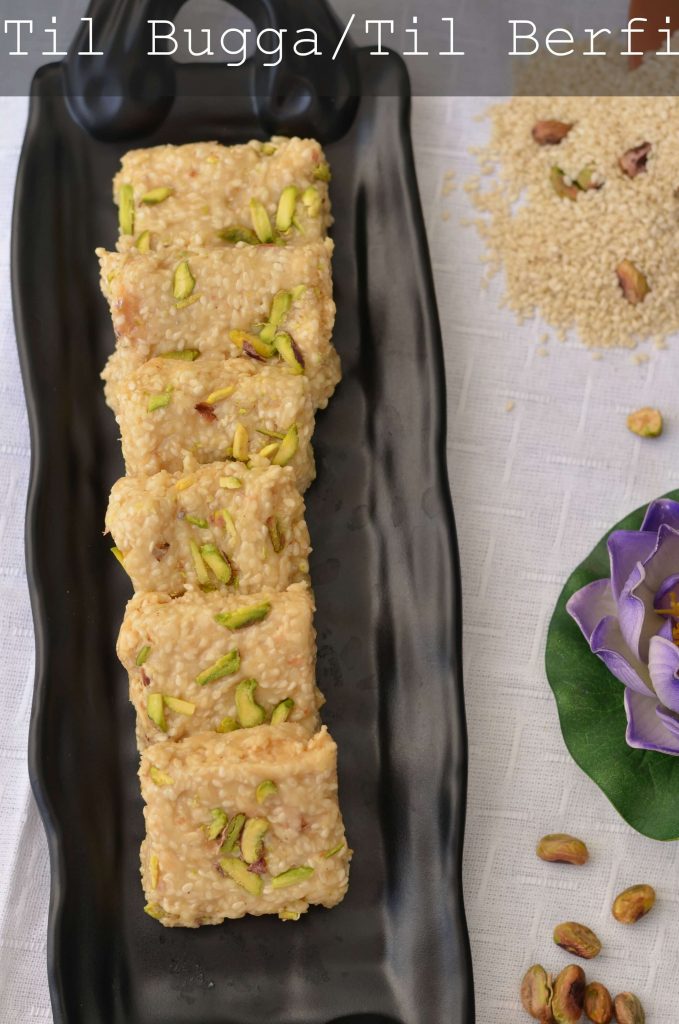 Til Bugga | MakarSankranti Special Til Bugga is served in black long serving tray. sesame seeds are spread at one place, click taken from top.