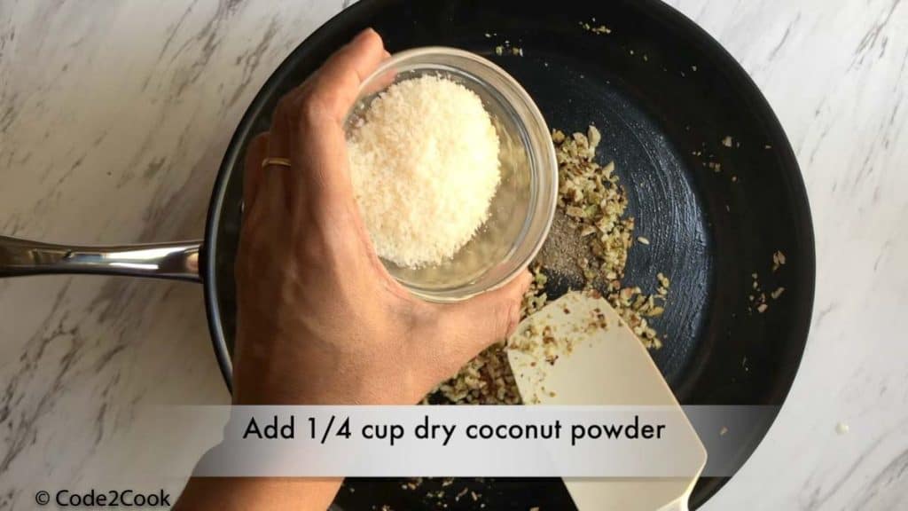adding desiccated coconut & cardamom powder to the mixture