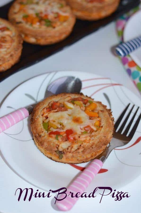 Mini Bread Disc Pizza | Quick & Easy Bread Pizza Mini bread disc pizza is a simple, easy and quick bread pizza recipe made with bread slices, filled with crunchy vegetables like bell pepper, olives, onion, tomatoes and finally topped with cheese. Mini bread disc pizza goes very well for breakfast, lunch or dinner or kids after-school snack.