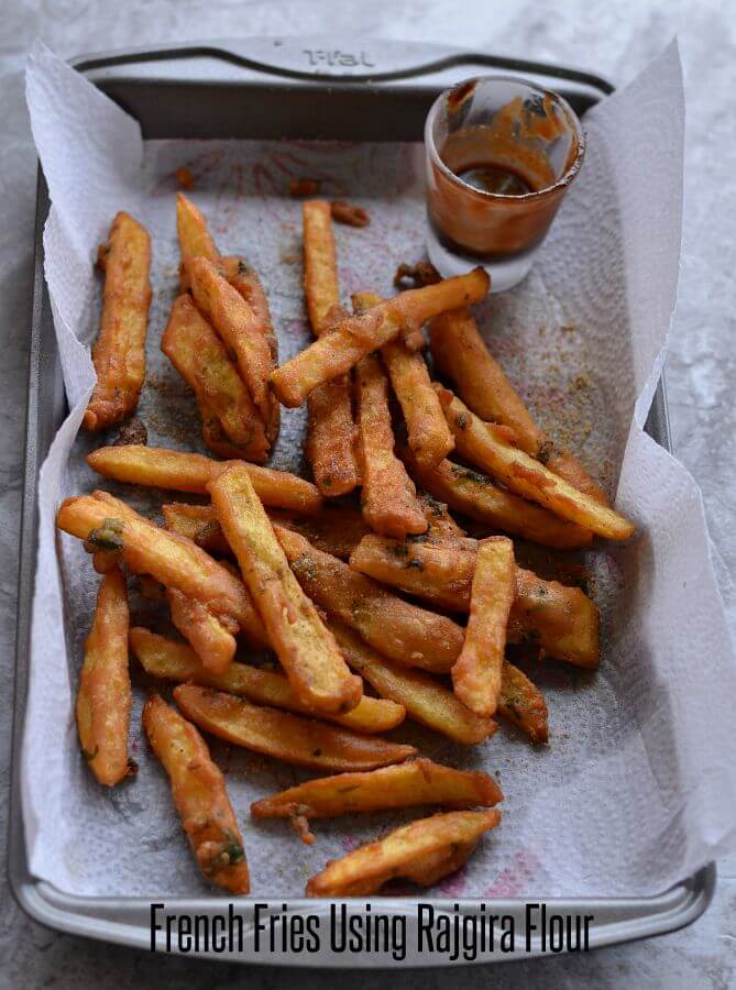 Farali French Fries | Vrat Ke French Fries | Rajgira Flour French Fries crunchy & crispy farali french fries served in a baking pan with tamarind chutney in a mini glass.