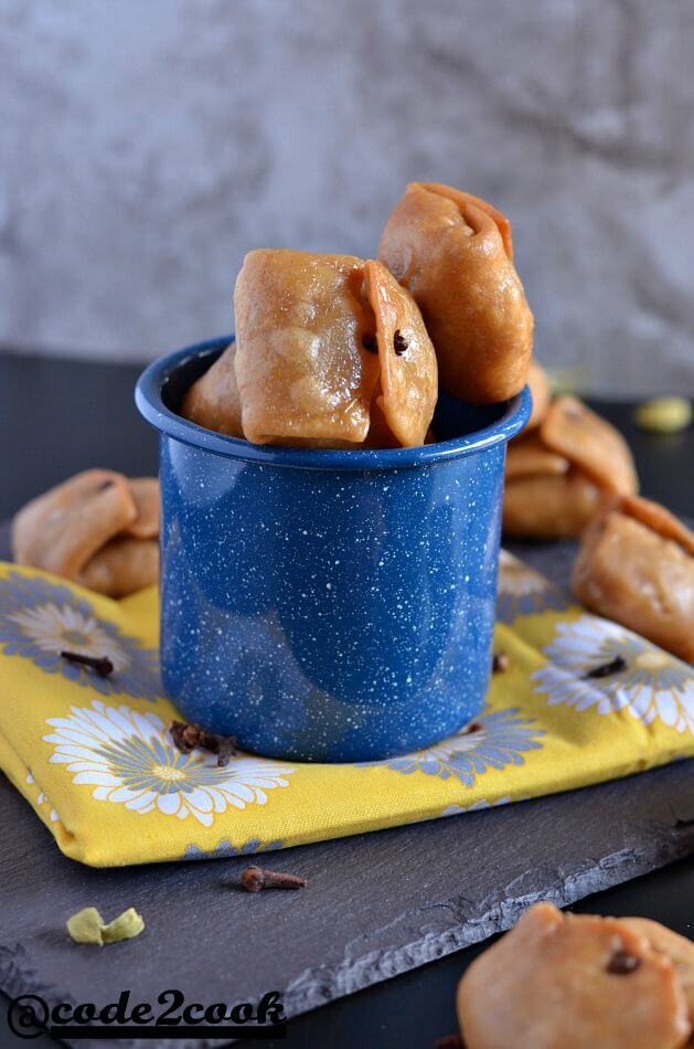 Whole Wheat Lavang Latika | Bengali Labongo Latika Recipe | Indian Festival Sweet Whole wheat Lavang Latika kept in blue enamel mug.