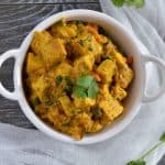 vegan sana thongba or vegan paneer curry click from up in a white serving bowl.