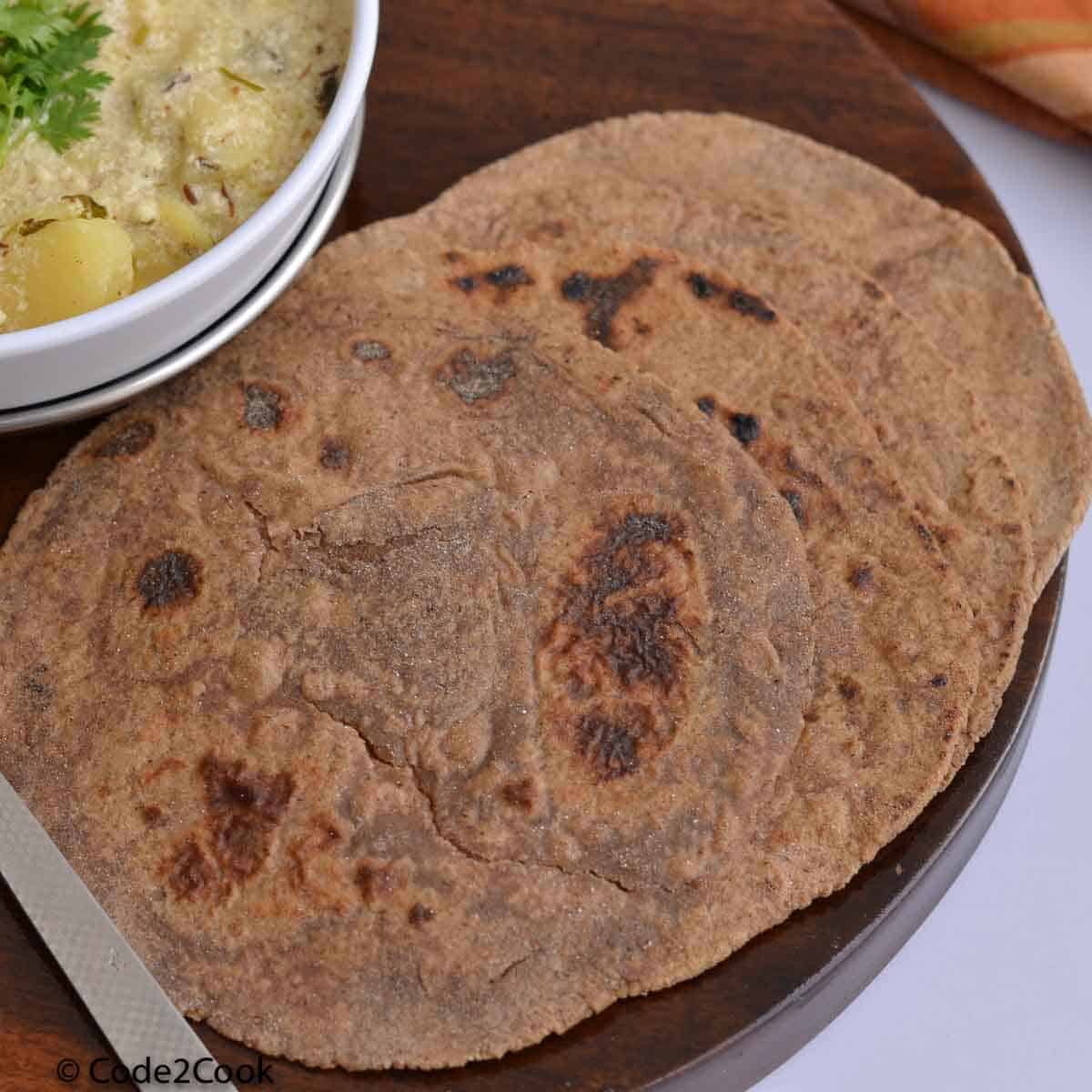 amarnath flour paratha served with dahi vale aloo on a wooden board.