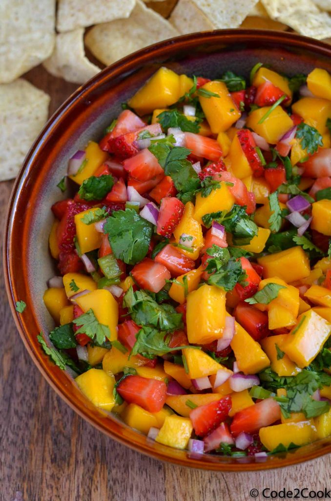close up of Strawberry Mango Salsa served in brown bowl.