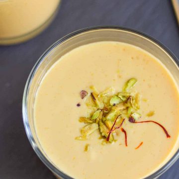 mango lassi served in a glass with garnishing
