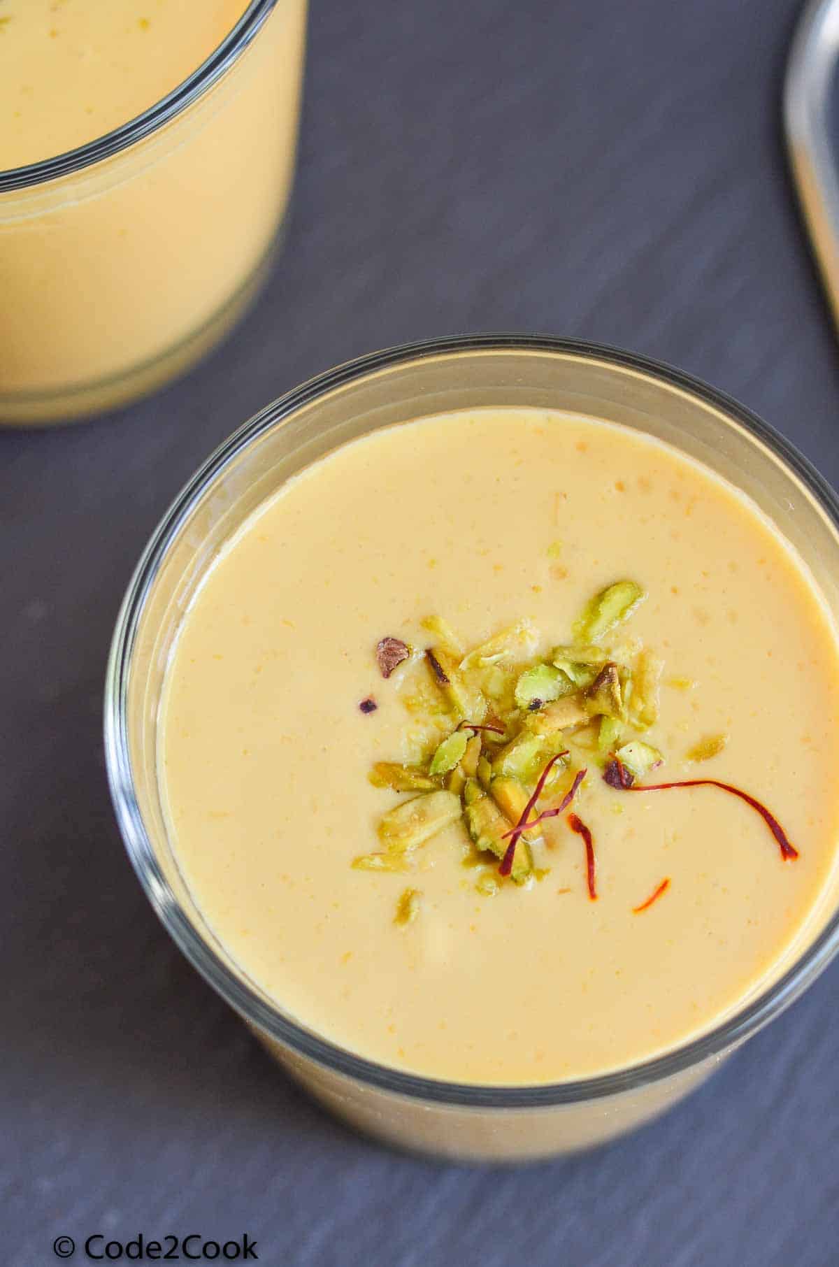 mango lassi served in a glass with garnishing