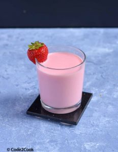 rooh afza milkshake served in a glass with strawberry