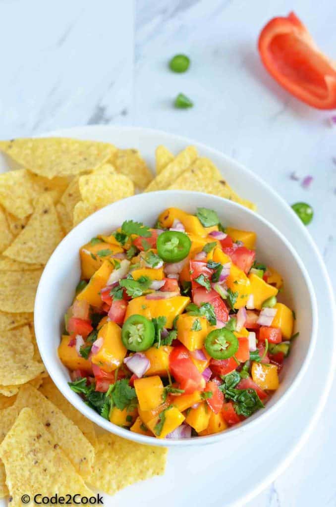 fresh mango salsa served in white bowl.