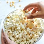 my son picking cooked popcorn from a bowl filled with them