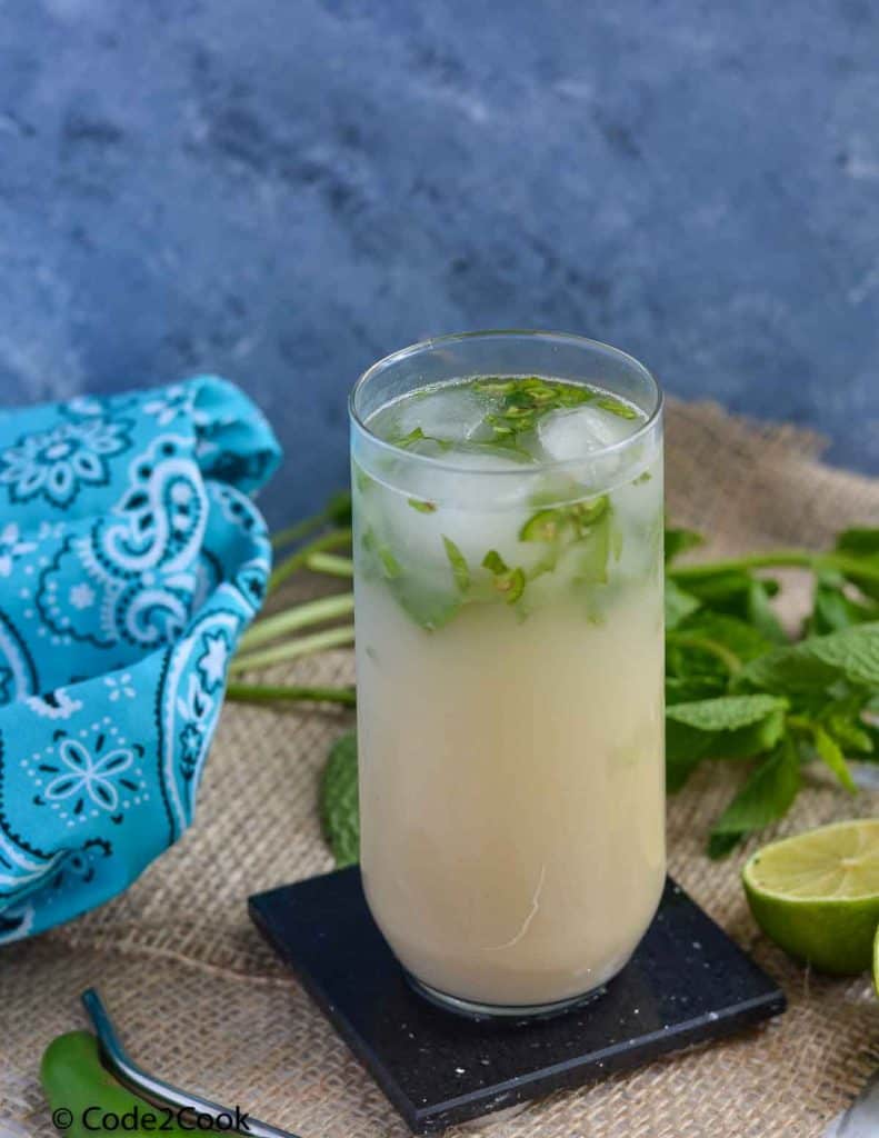 click of sattu drink served in tall glass and surrounded with mint, lemon and straw.