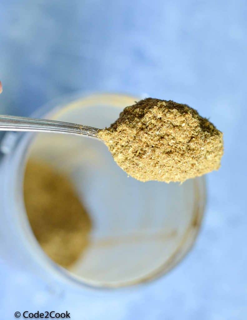 spoonful dhania powder shown from a grinding jar