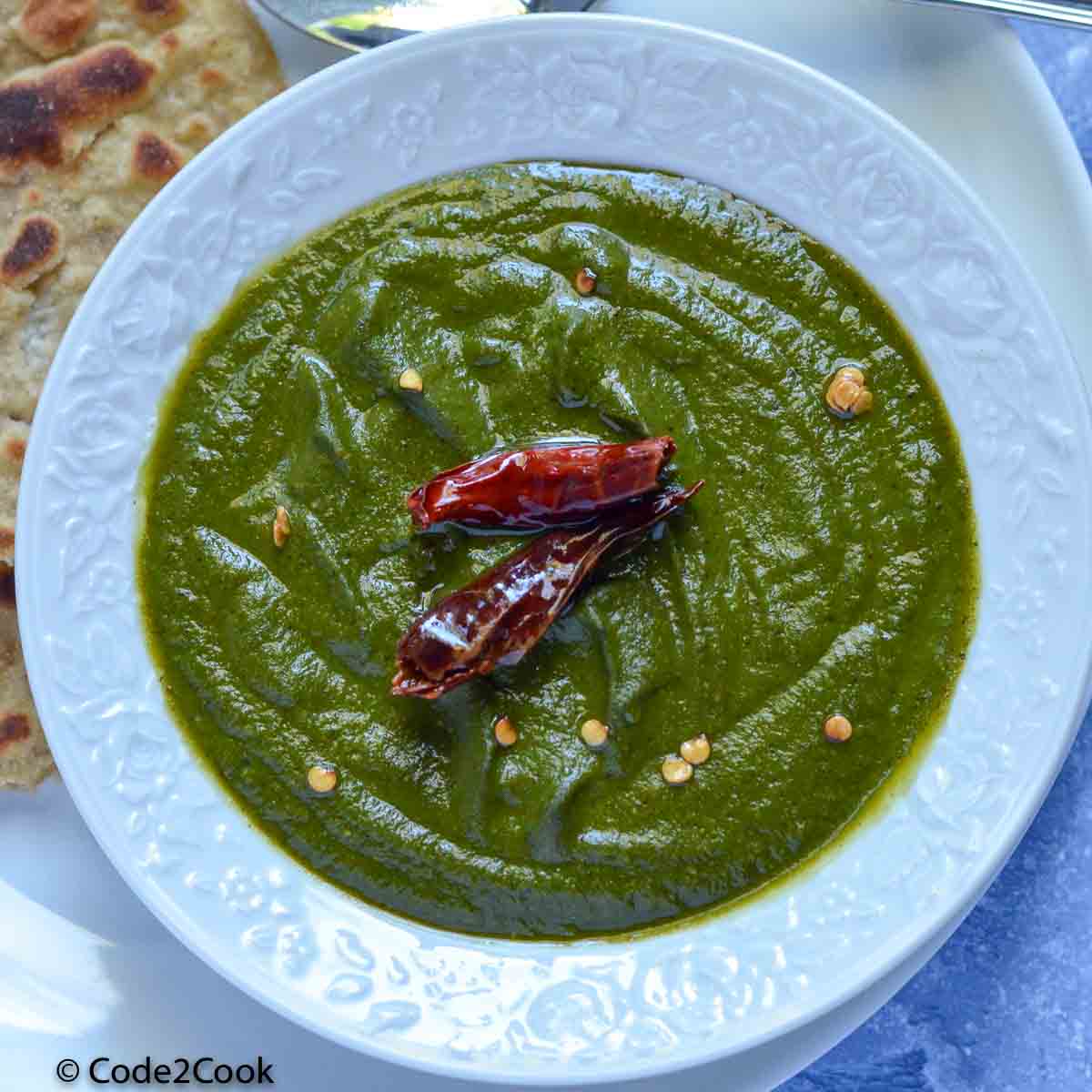 overhead shot of spinach chutney with dry red chili garnishing