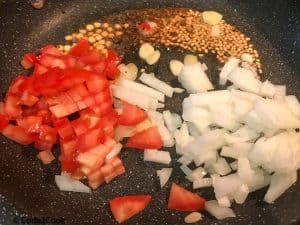 Adding, ginger,garlic, tomato & onion to the tempering