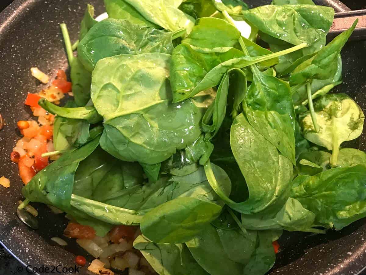 Adding spinach to the mixture.